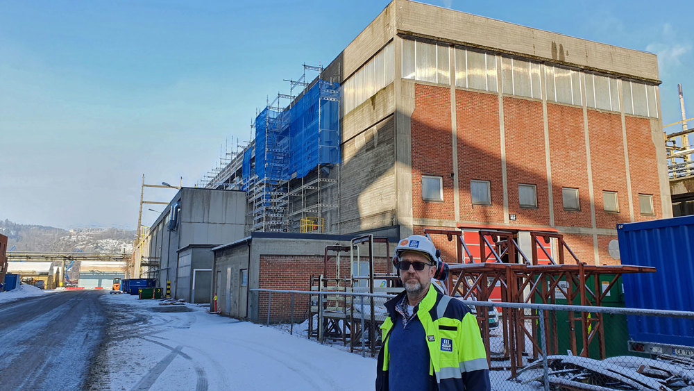 mann står utenfor mursteinsbygg, kompressorhall