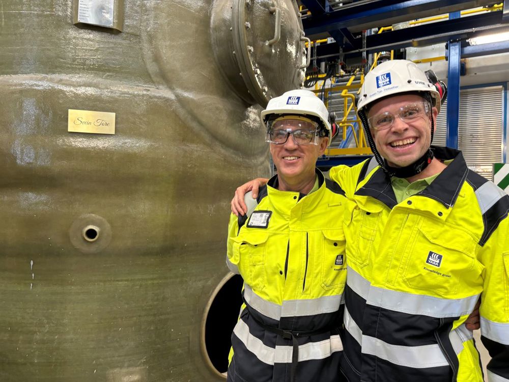 to menn, armen over skuldrene, smiler og poserer ved siden av en tank med navnet Svein Tore skrevet på.