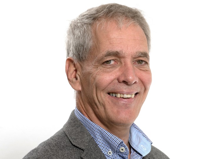 portrett av mann, grått kort hår, rutete skjorte, grå blazer