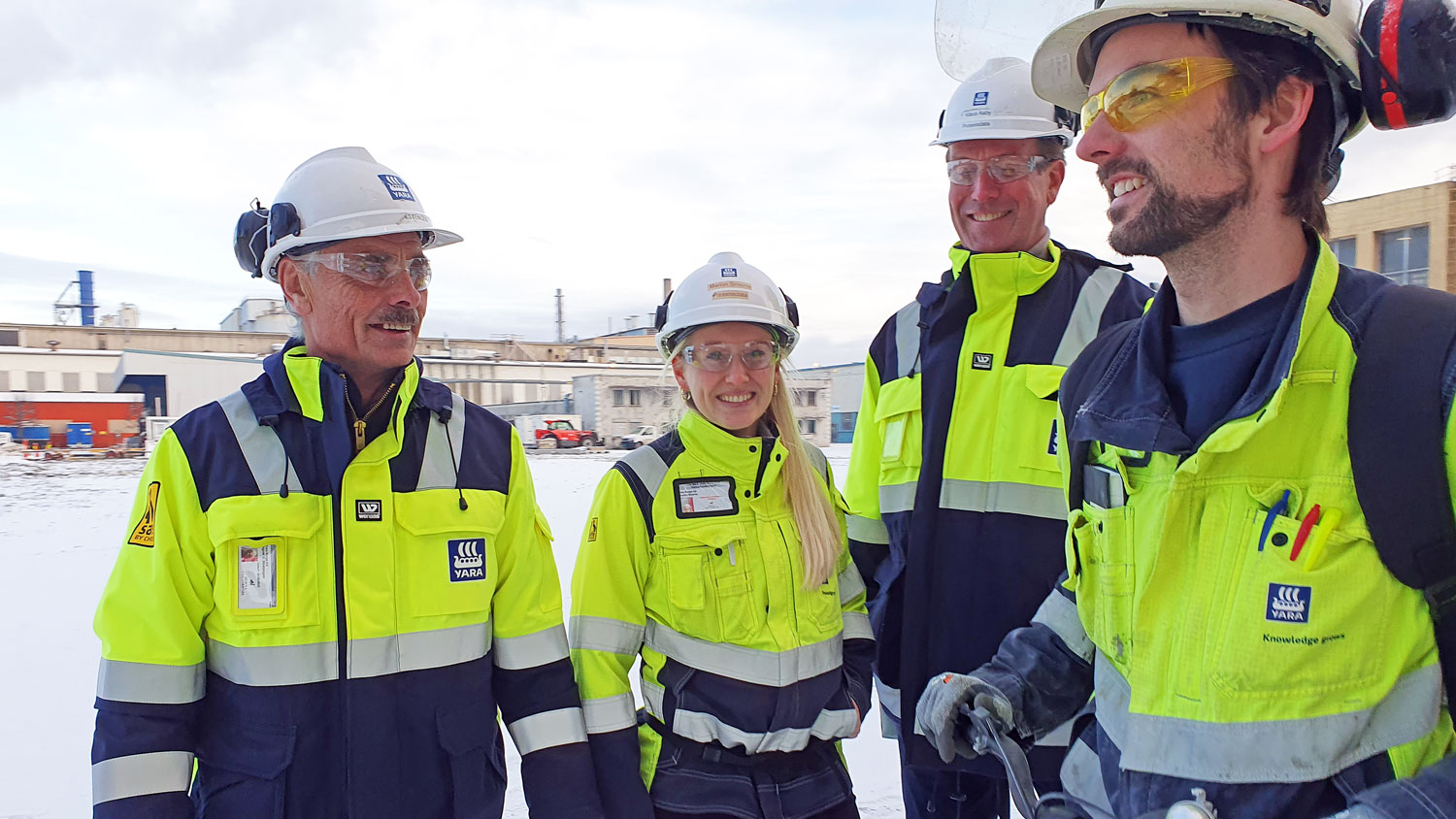 four people, work clothes, industry, outdoors, winter, posing.