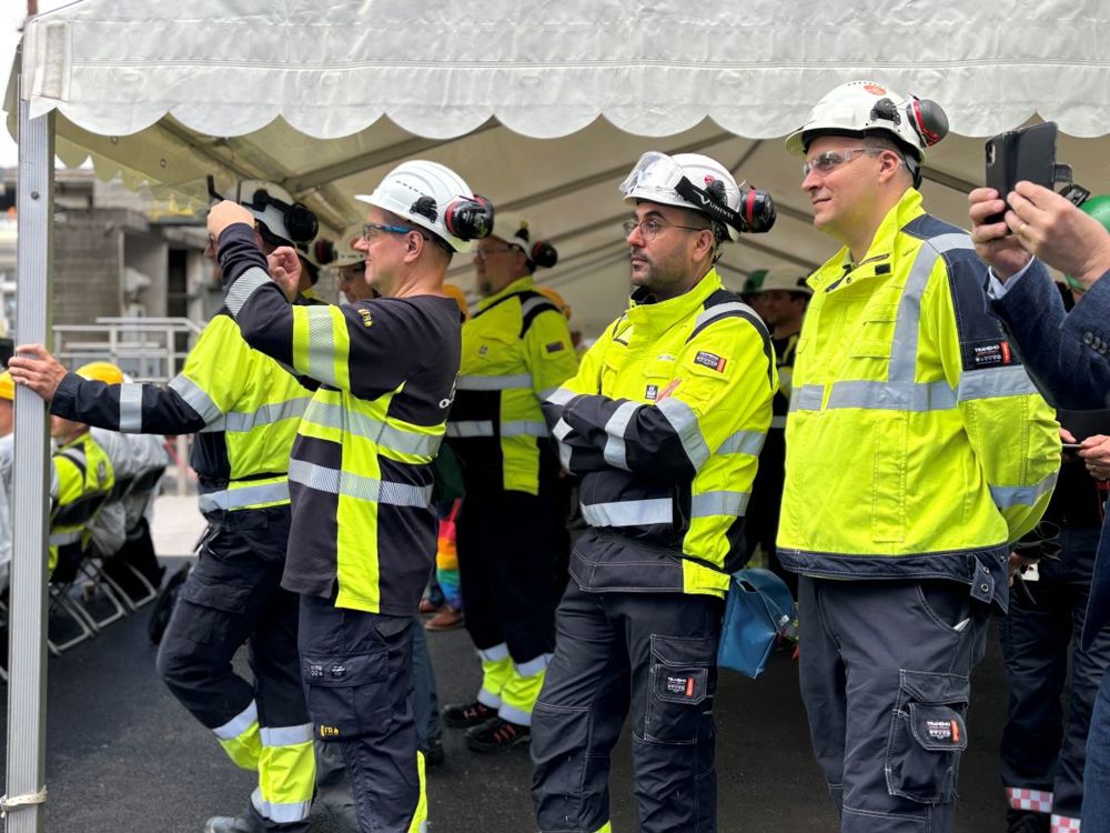 gruppe ansatte følger åpningsseremonien og fotograferer.