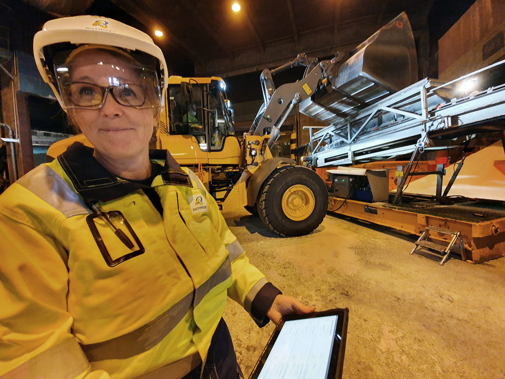 woman in wearhouse, monitoring information on pad