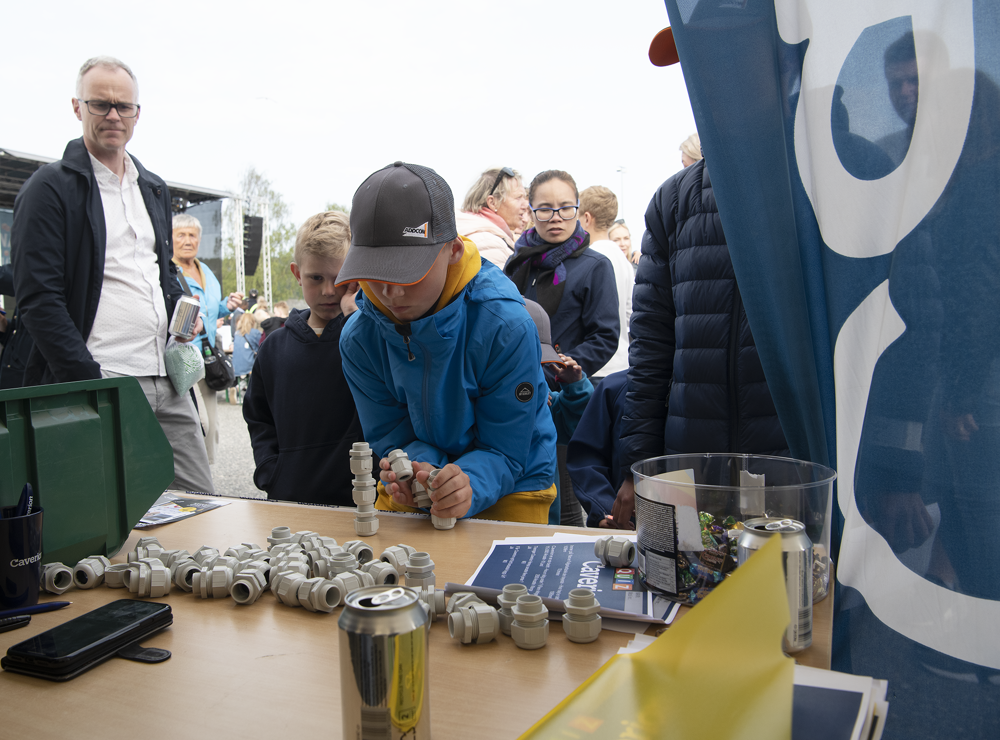 ung gutt i caps konsentrert og bygger tårn med elementer fra el-bedrift