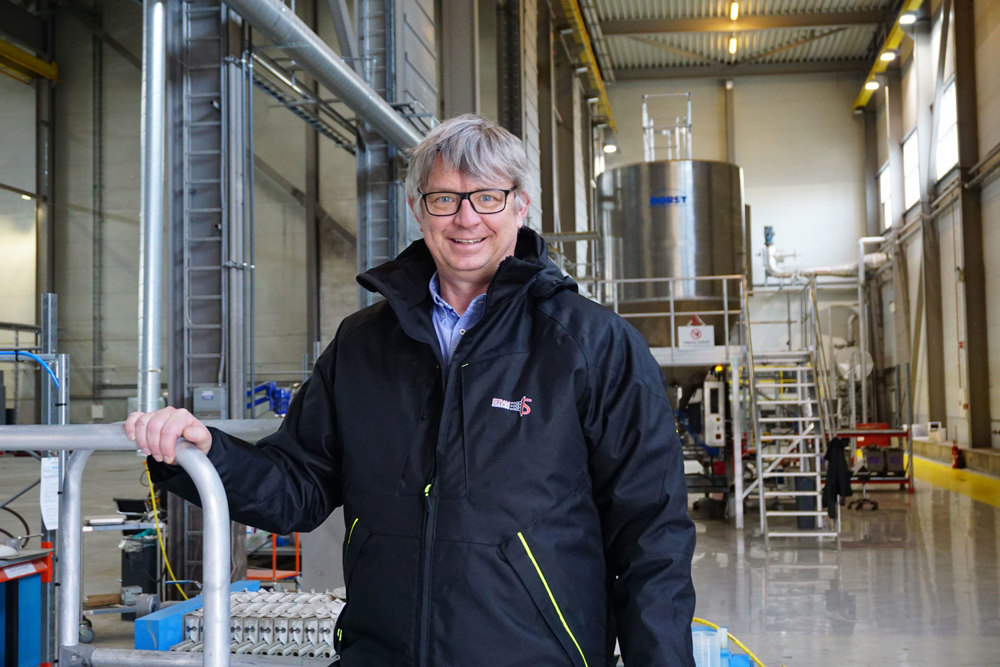 portrait of man, posing, standing in production hall, steel tank